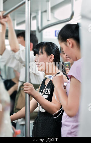 BEIJING-JUNE 2, 2015. Young girl in subway. Rapid transit rail network that serves Beijing urban and suburban districts, 18 lines, and 319 stations. Stock Photo