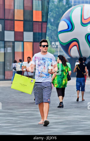 BEIJING-JUNE 25, 2014. Fashionable young man with Starbucks drink. Chinese consumers thirst for Starbucks coffee has more to do with status than taste. Stock Photo