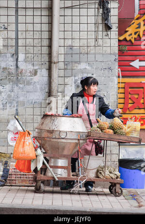 CHONGQING-OCTOBER 30, 2014. Female vendor sells street food. Chongqing is a paradise of food because of various exotic, spicy snacks. Stock Photo