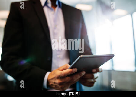 Close up of male hands using digital tablet in office. businessman man hand using tablet device. Stock Photo