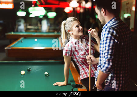 Young couple enjoying playing snooker on date together Stock Photo