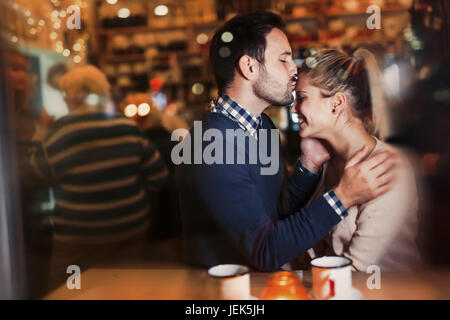 Happy attractive couple kissing at bar having date