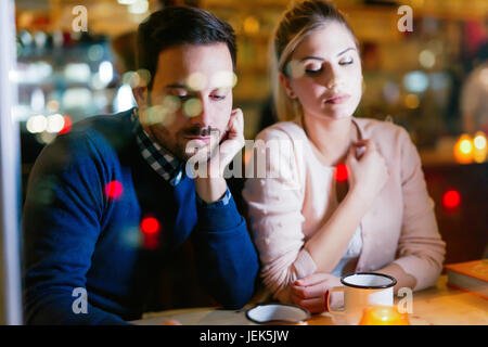 Sad couple having conflict and relationship problems sitting in bar