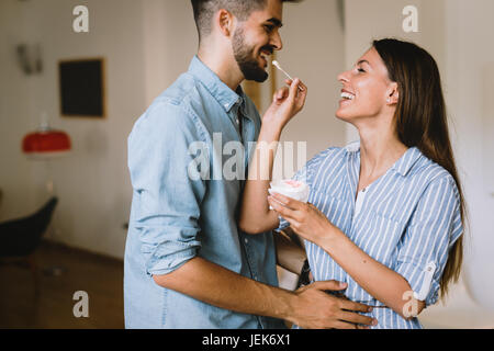 Beautiful couple in love having fun at home sharing ice cream Stock Photo