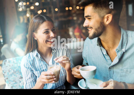 Young attractive cheerful couple on date in coffee shop Stock Photo