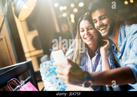 Young attractive cheerful couple on date in coffee shop