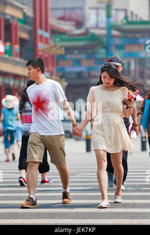 BEIJING-JUNE 9, 2015. Young lovers hand in hand. According 2010 national census, China’s unmarried population is huge: about 249 million 18-and-older. Stock Photo