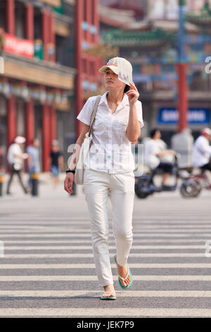 BEIJING-JUNE 9, 2015. Woman protects her face against a strong sun. Since ancient times a pale skin is an absolute Chinese beauty ideal. Stock Photo