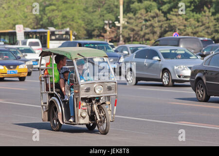 BEIJING-MAY 29, 2013. Tricycle motor taxi downtown. This small taxi is similar to Thailand Tuk Tuks, Philippines Tricycles and Vietnam Cyclo. Stock Photo