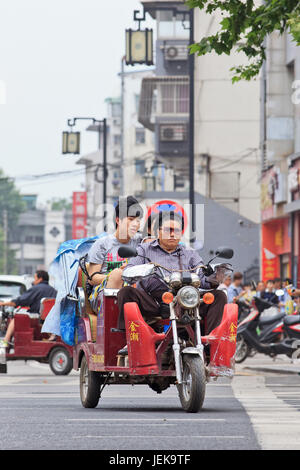 NANJING-MAY 25, 2014. Tricycle motor taxi. They are often seen in urban-rural fringe area, where public transportation services are insufficient. Stock Photo