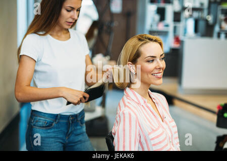 Portrait of beautiful young woman getting haircut in beauty salon Stock Photo