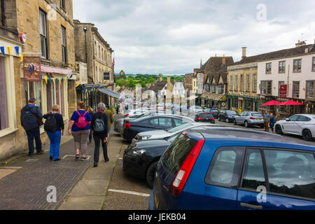 Tourists make thier way along the Hill Burfords main street Oxfordshire England UK Stock Photo