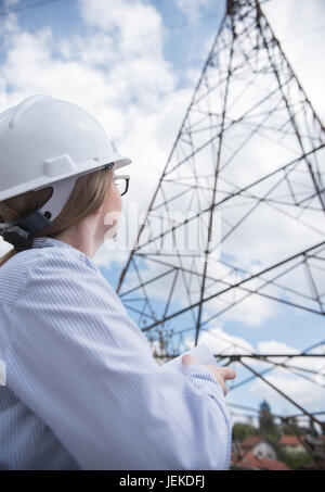 Female engineer looking at power lines Stock Photo