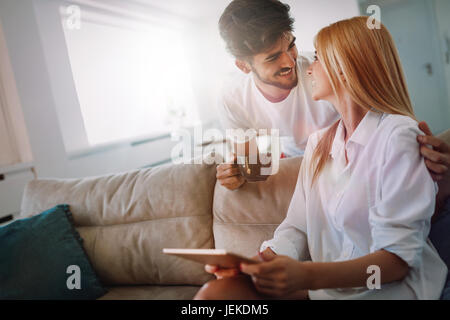 Young attractive couple spending time together at home using tablet Stock Photo