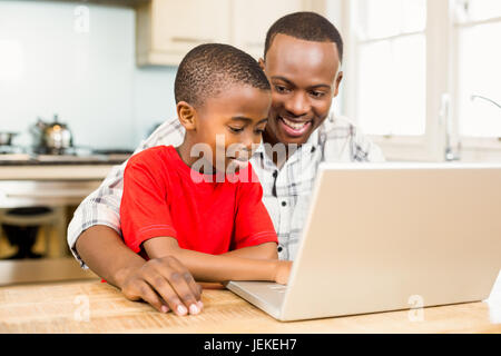 Father and son using laptop together Stock Photo