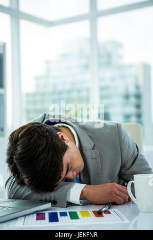 Asian businessman sleeping on his desk Stock Photo