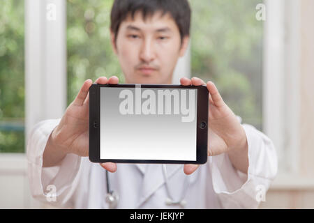 The doctor holds in hand before himself a tablet Stock Photo