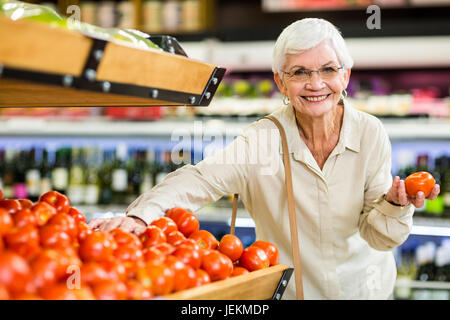 Senior woman choosing her tomatoes Stock Photo
