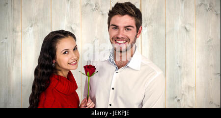 Composite image of smiling couple with rose Stock Photo