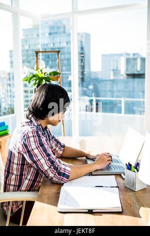Serious hipster businessman using laptop Stock Photo