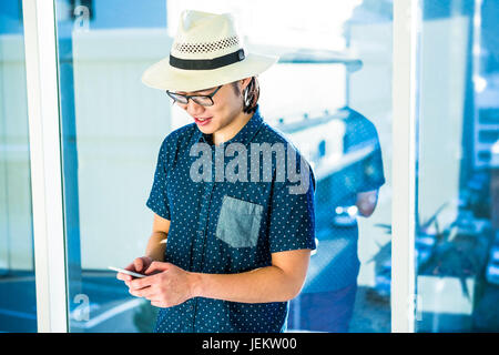 Smiling hipster businessman texting Stock Photo