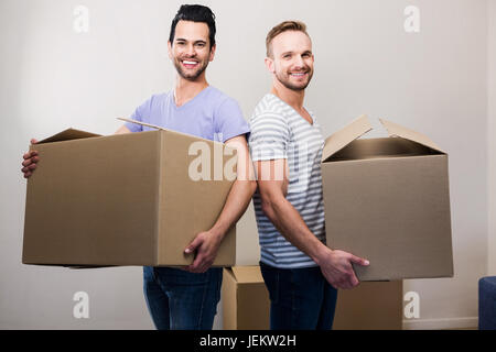 Happy gay couple holding boxes Stock Photo - Alamy