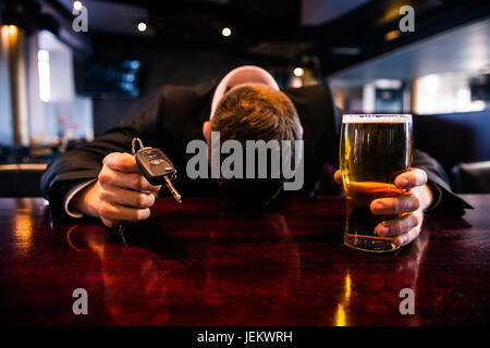 Drunk man holding a beer and car keys