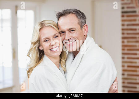 Cute couple cuddling in bathrobes Stock Photo