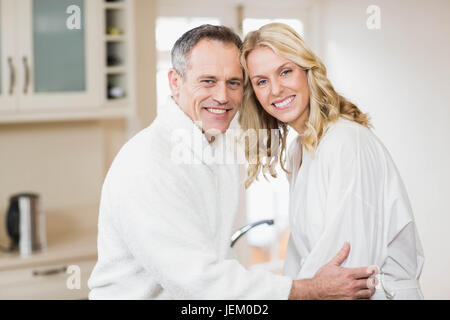 Cute couple cuddling in bathrobes Stock Photo