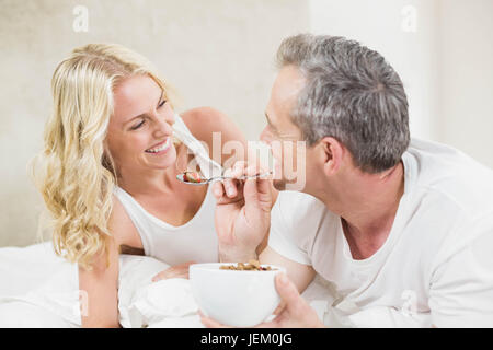 Cute couple having breakfast in bed Stock Photo