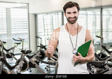 Smiling trainer showing thumb up Stock Photo