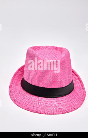 Pink woven hat, white background. Summer headgear accessory for beach. Stock Photo