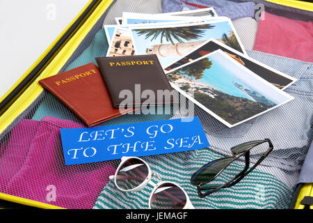 Tourism accessories on suitcase.n Passports, glasses, photos, paper note. Stock Photo