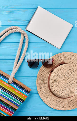 Straw panama, notebook, sunglasses, handbag. Beach accessories close up, vintage background. Stock Photo