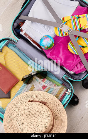 Panama on suitcase, top view. Opened packed luggage for summer journey. Stock Photo