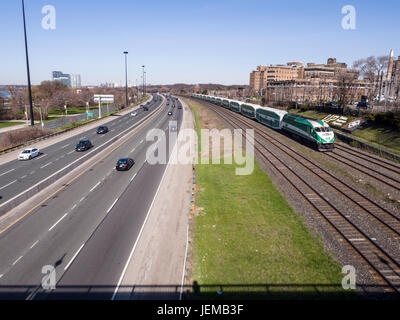 Gardiner and Go Train along the waterfront: A lightly travelled Gardiner Expressway as a GO train approaches the center of Toronto on a quiet sunday morning. Stock Photo