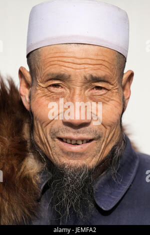 Muslim vendor with a white skullcap in Beijing.  According a Pew Research Center study, based on China's census, there are 21,667,00 Muslims in China. Stock Photo