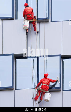 BEIJING - APRIL 28, 2009. Window cleaners at work. They are known as spider-men because they entrust their lives to a single thread, made of hemp. Stock Photo