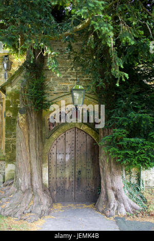 Yew trees flanking door in the north porch of St Edwards parish church in Stow on the Wold Stock Photo