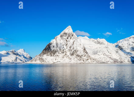 Mount Olstind reflected in the calm waters of Reinefjord on the Lofoten Islands