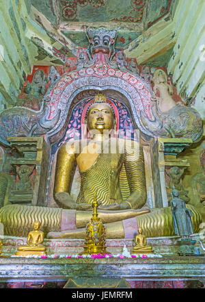 PILIMATHALAWA, SRI LANKA - NOVEMBER 11, 2016: The golden statue of Lord Buddha in main shrine room of Gadaladeniya Vihara Buddhist Temple, the carved  Stock Photo