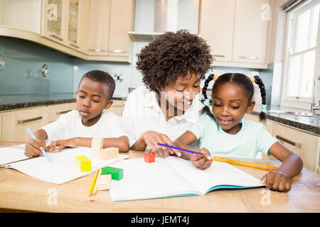 Mother checking children homework Stock Photo