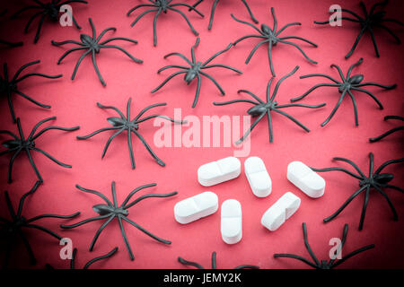 Spiders around capsules, concept phobia to medicines Stock Photo