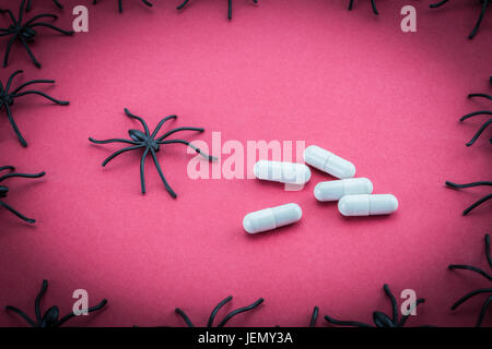 Spiders around capsules, concept phobia to medicines Stock Photo