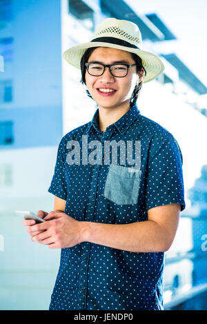 Smiling hipster businessman texting Stock Photo
