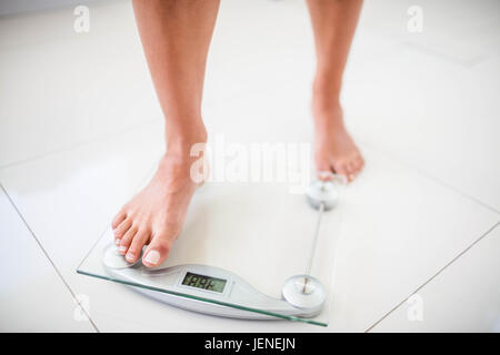 Womans feet going on weighting scale Stock Photo
