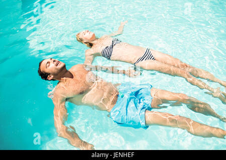 Peaceful couple floating in the pool Stock Photo