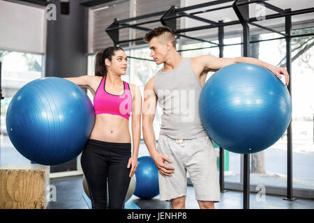 Fit couple posing with sport ball Stock Photo