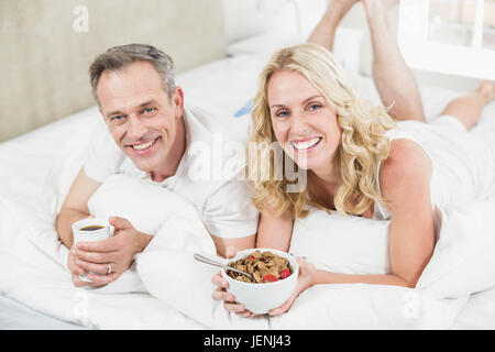 Cute couple having breakfast in bed Stock Photo