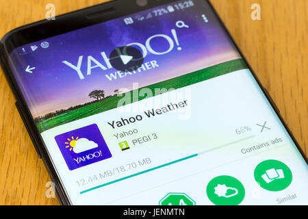 A closeup on the Yahoo Weather app being downloaded on a Samsung Galaxy S8 Stock Photo